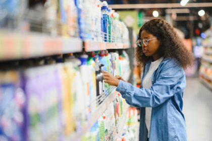 Young woman checking labels of a product in an African supermarket