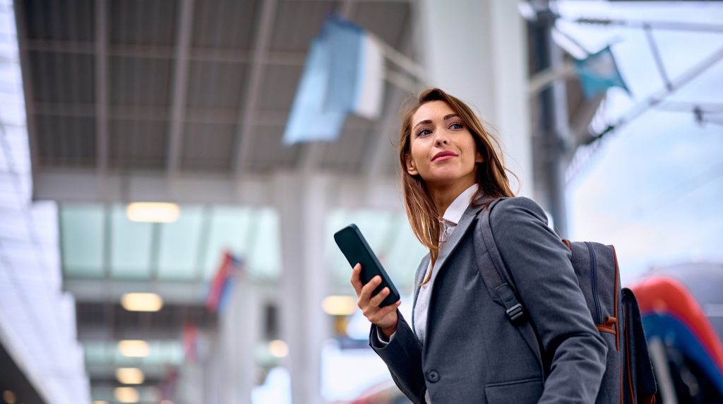 Woman using a mobile phone in an airport during international travel
