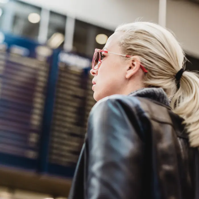 A woman looking at the departure flight board at the airport