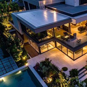 Luxury modern villa at dusk with landscaped gardens and a swimming pool, representing residential security and executive protection.